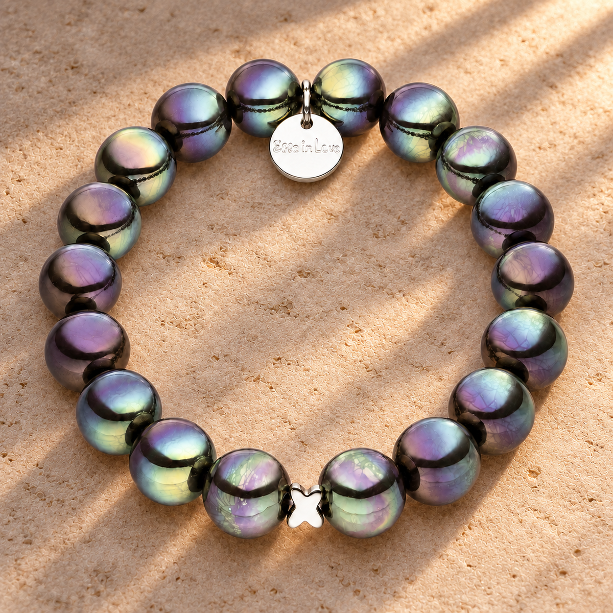 Perlenarmband Dunkelgrau mit 3D Intensiv Glow Effekt – auf champagnerfarbenem Hintergrund im warmen Abendlicht.