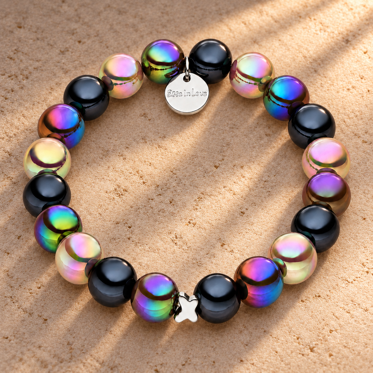 Perlenarmband Multi Schwarz mit 3D Intensiv Glow Effekt – auf champagnerfarbenem Hintergrund im warmen Abendlicht.