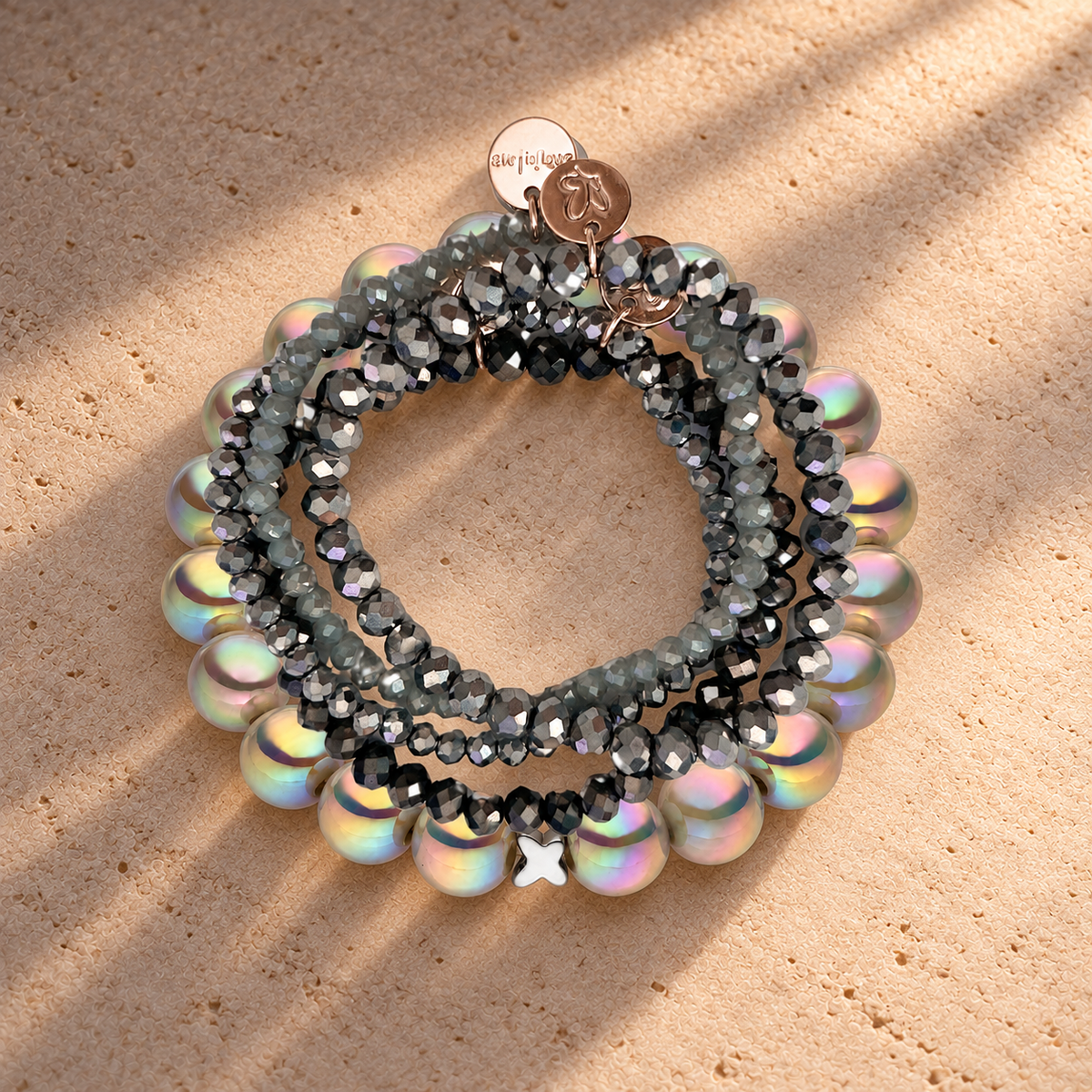 Perlenarmband-Set Silber–Hellgrau mit Schmetterling – 5-teilig mit 3D Intensiv Glow 10 mm – auf champagnerfarbenem Hintergrund im warmen Abendlicht.