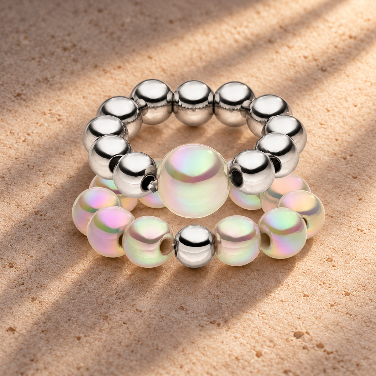Perlenring Set 14K Versilbert Hellgrau mit 3D Intensiv Glow Effekt – auf champagnerfarbenem Hintergrund im warmen Abendlicht.