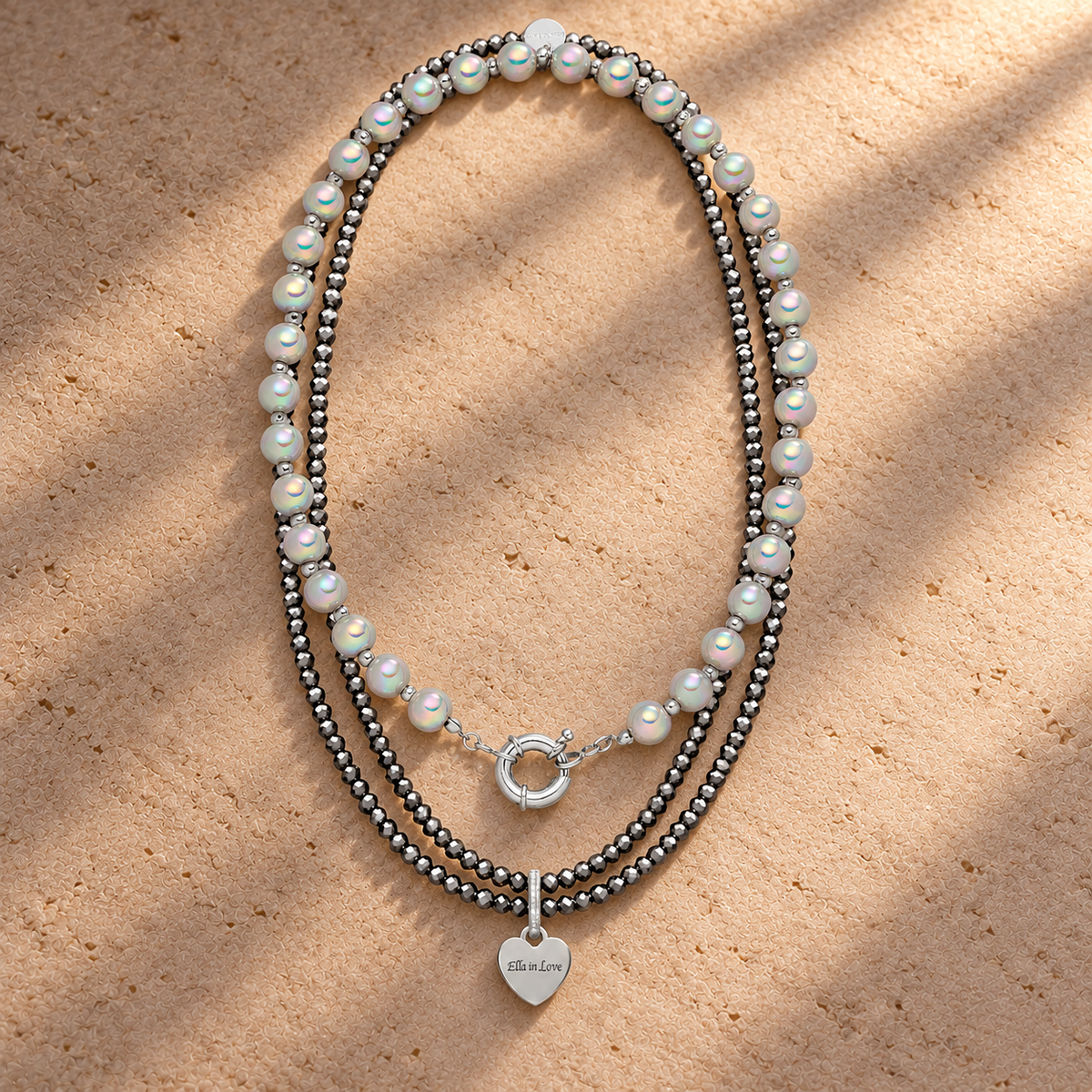 Perlenhalsketten-Set Silber–Hellgrau mit Herz-Charm – 3D Intensiv Glow 10 mm (45 cm) & wasserfeste Kette 110 cm – auf champagnerfarbenem Hintergrund im warmen Abendlicht.