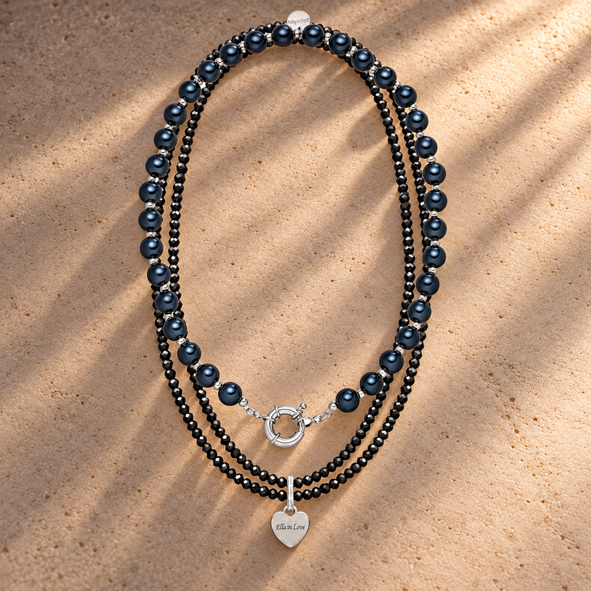 Perlenhalsketten-Set Schwarz mit Herz-Charm – 3D Intensiv Glow 10 mm (45 cm) & wasserfeste Kette 110 cm – auf champagnerfarbenem Hintergrund im warmen Abendlicht.